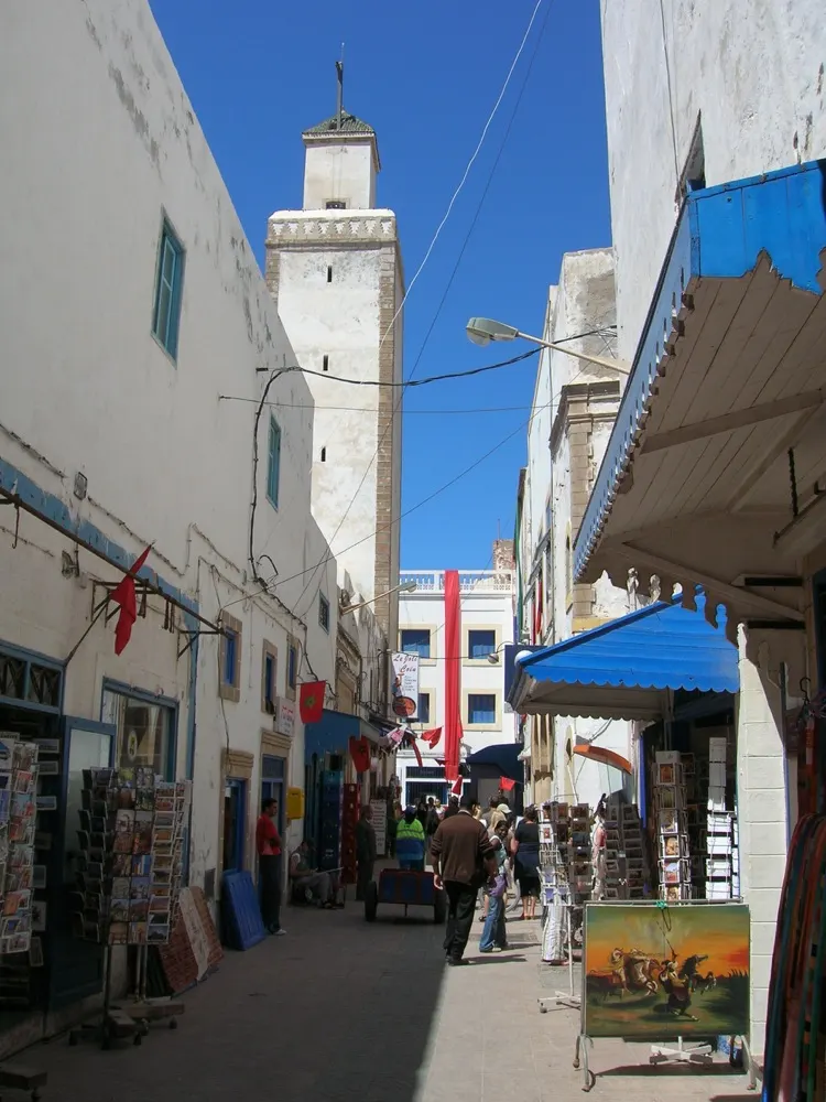 A street in Essaouira lined with pale buildings and blue details.